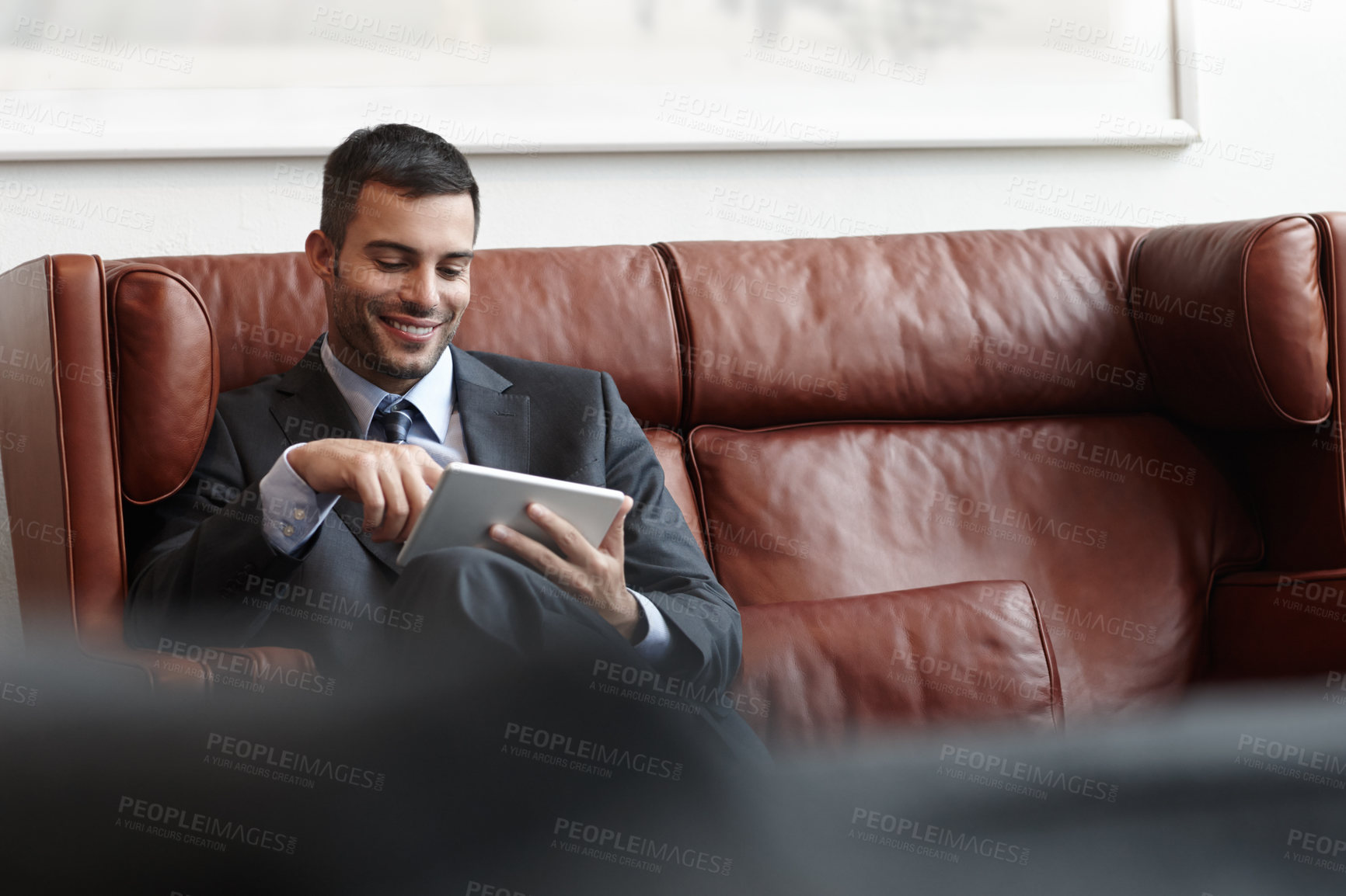 Buy stock photo Reading, tablet and happy businessman on couch for online, research and social media in waiting room. Trader, internet and technology for streaming, digital news and email for meeting or company  