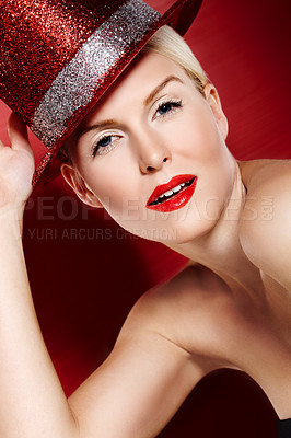 Buy stock photo Portrait of a beautiful showgirl with red lipstick and a sparkly red hat against a red background