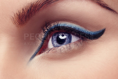 Buy stock photo Closeup of a female eye wearing makeup with blue shimmer eyeshadow and black winged liner. Macro closeup of a woman with beautiful eyes wearing mascara and other cosmetics to make her eyes pop
