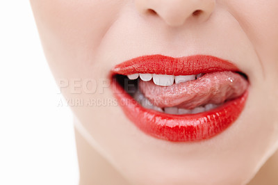Buy stock photo Cropped closeup shot of a woman licking her lips with vibrant lipstick on