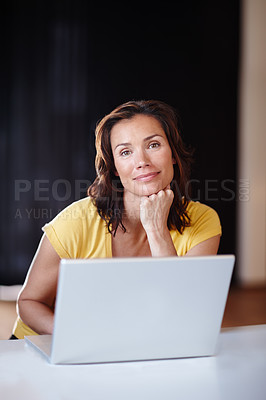 Buy stock photo Portrait of a woman sitting with a laptop and smiling. Female with hand on her chin in front of a computer. Mother working from home during her quarantine. Lady doing remote work for her startup 