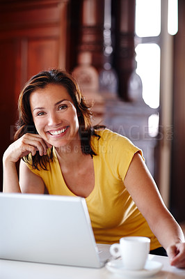 Buy stock photo Business woman doing remote work for her online startup. Portrait of a business woman working on a laptop in a coffee shop and smiling. Female entrepreneur sitting in front of a computer in a cafe