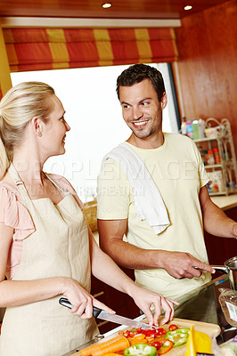 Buy stock photo Couple, smile and cooking together in kitchen for vegan lunch, diet nutrition and bonding in home. Happy, woman and man by stove with food for vegetarian dinner, healthy marriage and chop vegetable