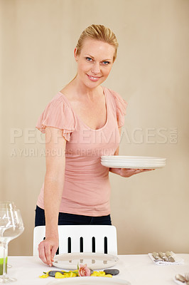 Buy stock photo Woman, portrait and table setting for dinner party, event or celebration with hostess and helping. Plate, smile and prepare for meal in dining room with flower, home and cutlery for food and lunch