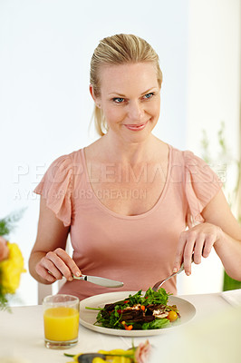 Buy stock photo A beautiful woman enjoying a healthy lunch in her dining room