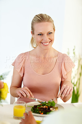 Buy stock photo A beautiful woman enjoying a healthy lunch in her dining room