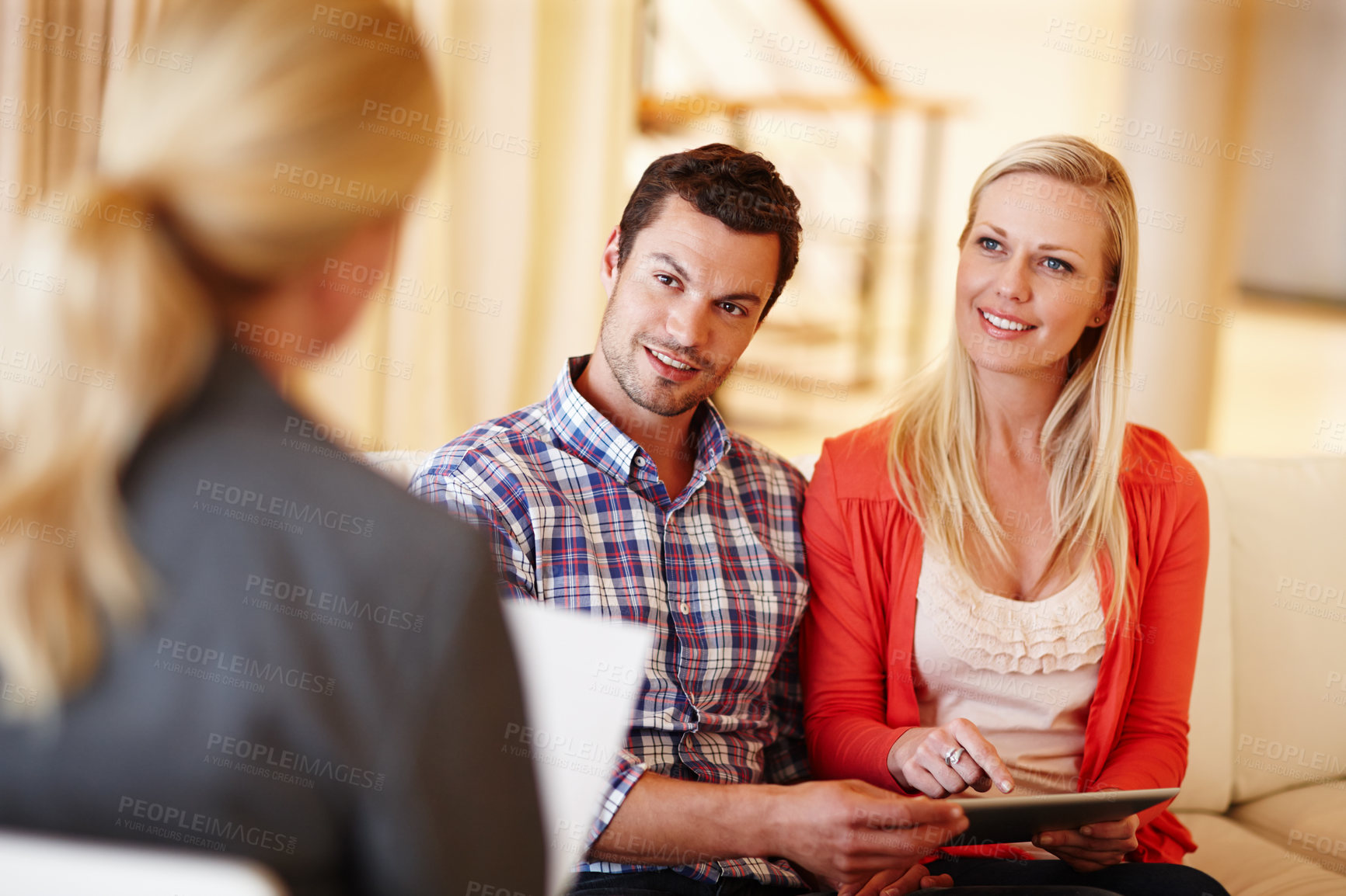 Buy stock photo A happy couple getting advice from a financial consultant in their home