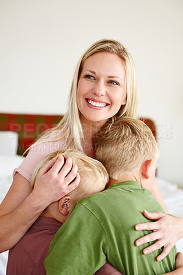 Buy stock photo A smiling mother hugging her two sons