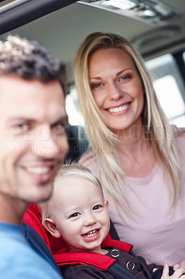 Buy stock photo Portrait of a smiling father and mother next to their toddler who is sitting in his baby seat