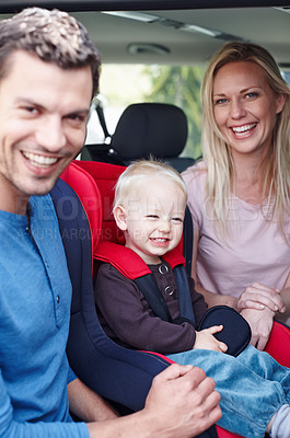 Buy stock photo Portrait of a laughing father and mother next to their toddler who is sitting in his baby seat