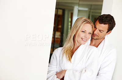 Buy stock photo A loving young couple in bathrobes relaxing at home