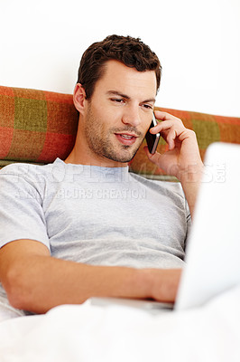 Buy stock photo Man, relax and phone call in bed with laptop or smartphone for social media, streaming and subscription. Male person, chill and digital communication in home with tech for  internet, movie and app