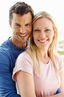 Buy stock photo A happy young couple standing together and smiling
