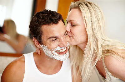 Buy stock photo Shaving, kiss and couple in bathroom with smile, romance and getting ready for beard care. Love, happy woman and man with bonding, foam and hair removal in morning cleaning routine at home together