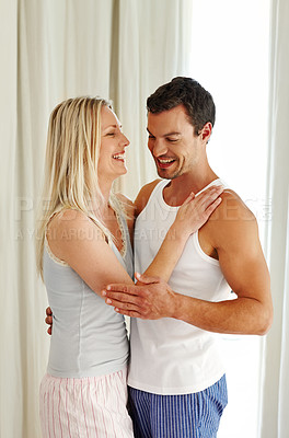 Buy stock photo Couple, hug and laugh in home for love in relationship, romance and weekend for speaking. People, embrace and together for affection in marriage, bonding and support in conversation or funny joke