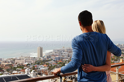 Buy stock photo A happy couple standing on a balcony looking over the view