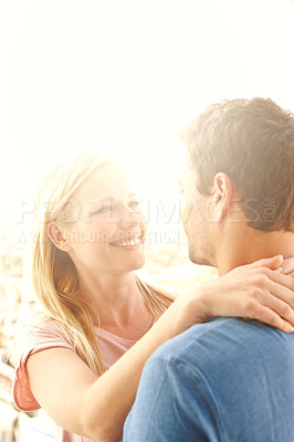 Buy stock photo A happy couple in the sunshine holding each other and smiling
