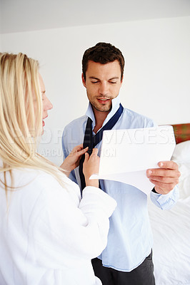 Buy stock photo A woman helping her husband get ready for a business meeting