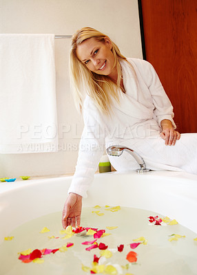 Buy stock photo Portrait, bathtub and happy woman in a bathroom for beauty, relax and selfcare with petal body care at home. Water, flowers and face of girl person with bathrobe, smile or diy spa treatment in house