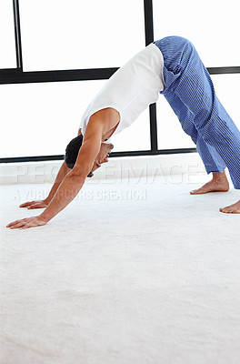Buy stock photo A handsome man doing stretching exercises
