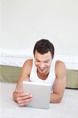 Buy stock photo Relax, tablet and man on floor for social media, online streaming and internet in bedroom. Happy, resting and person on digital technology for reading website, news and research on weekend at home