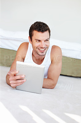 Buy stock photo Happy, tablet and man on floor in bedroom for social media, online streaming and internet videos. Relax, resting and person on digital tech for reading website, news and thinking on weekend at home