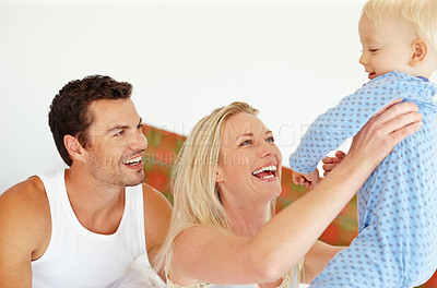 Buy stock photo Happy, love or parents lifting baby in bedroom with support, bonding and playing morning games at home together. Family, learning or people in house with security, trust or care for child development