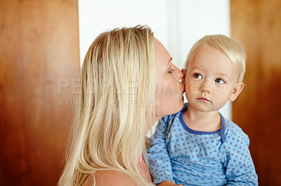Buy stock photo A beautiful mother kissing her young boy on the cheek