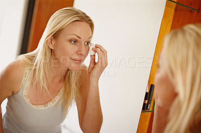 Buy stock photo A lovely young woman cleaning her face with cotton wool