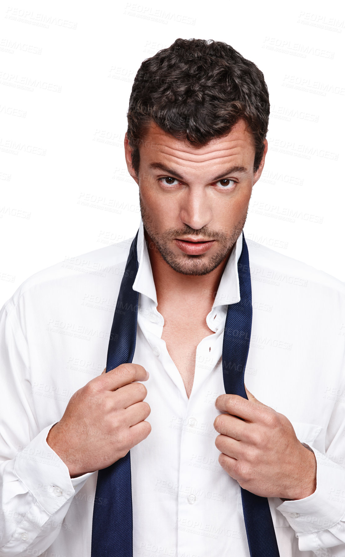 Buy stock photo A young man putting on his tie while isolated on a white background