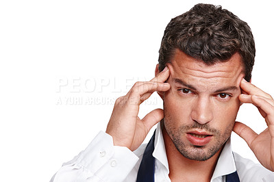 Buy stock photo A young man suffering from a rooting headache while isolated on white
