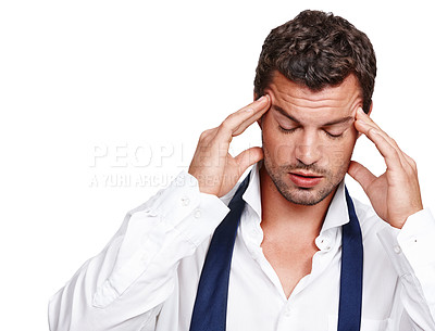 Buy stock photo A young man suffering from a rooting headache while isolated on white