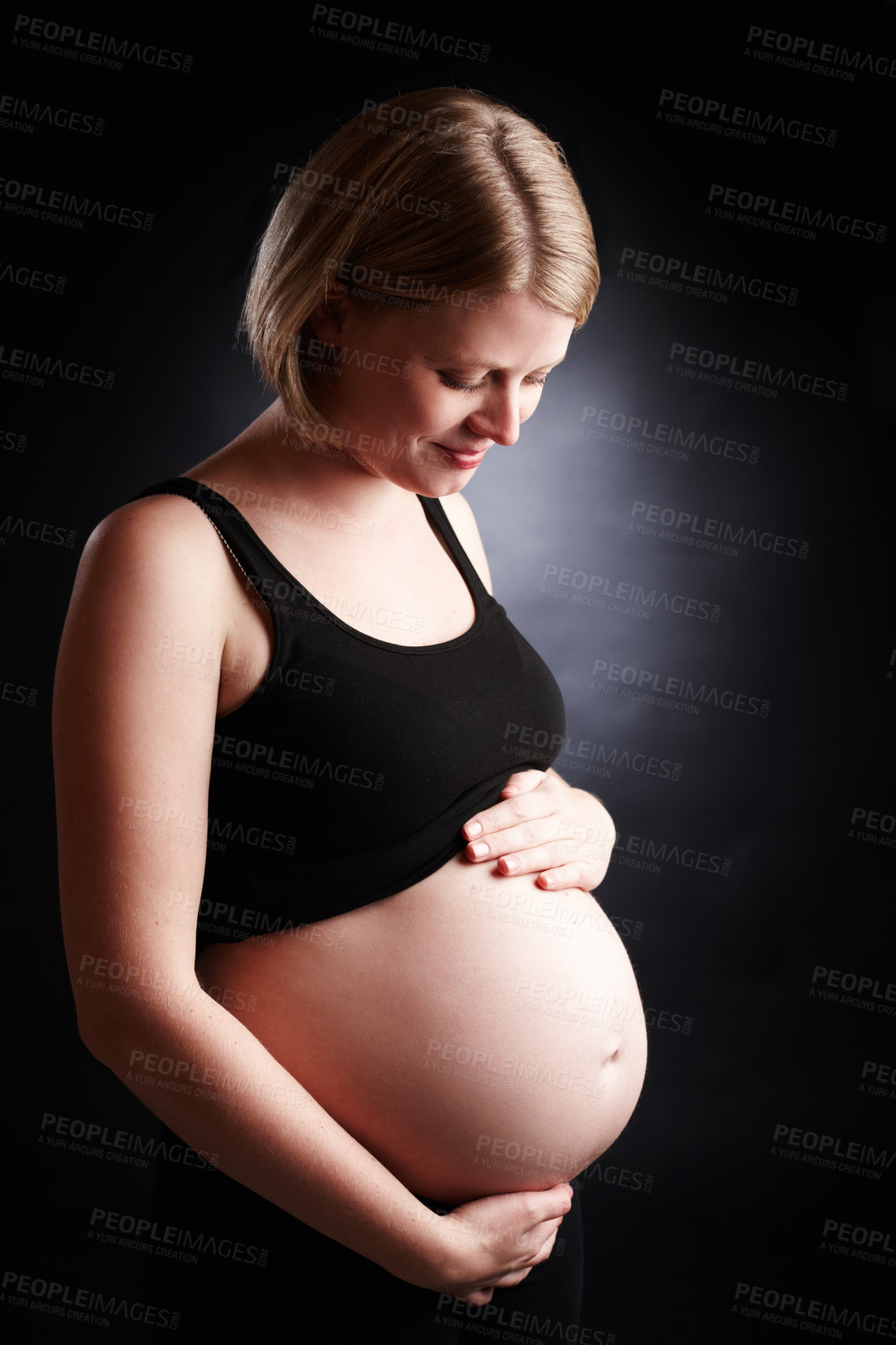 Buy stock photo Pregnant, mother and care with belly in studio, baby bump and woman in pregnancy. Black background, gestation and gynecology for stomach growth, maternity wellness and motherhood for family planning