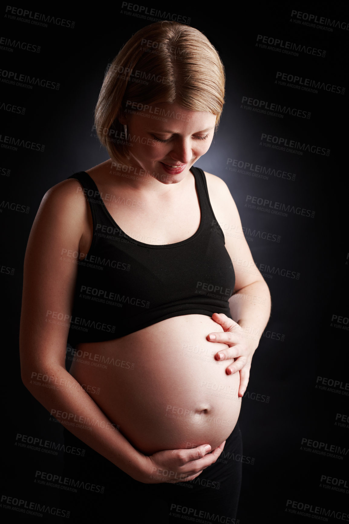 Buy stock photo Pregnant, mother and care with tummy in studio, baby bump and woman in pregnancy. Black background, gestation and gynecology for stomach growth, maternity wellness and motherhood for family planning