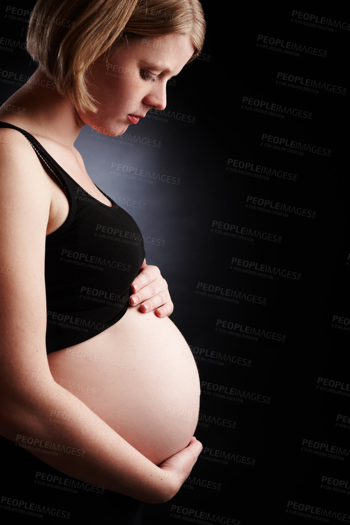 Buy stock photo Pregnant, woman and serious with belly in studio, baby bump and mother or unwanted pregnancy. Black background, gestation period and gynecology or family planning crisis, maternity and stomach growth