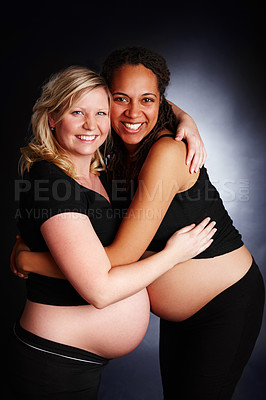 Buy stock photo Pregnant, friends and studio or hug with stomach, bonding and woman together for diversity support. Family planning, maternity and pregnancy care, gestation and gynecology on happy black background