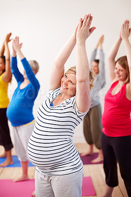 Buy stock photo A multi-ethnic group of pregnant women doing exercises with their arms stretched upwards