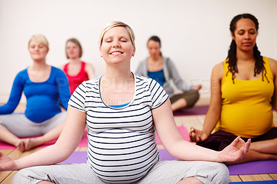 Buy stock photo A multi-ethnic group of pregnant women meditating in a yoga class