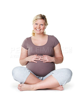 Buy stock photo Pregnant, happy and healthy woman sitting with her hands on her stomach while enjoying her pregnancy against a white background. Health, wellness and hope of a mother to be ready for childbirth