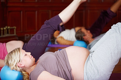 Buy stock photo Woman, class and prenatal yoga for stretching, health and wellness with ball, exercise and therapy. Mother, pregnant and workout in studio for fitness, group and body awareness with leg raise