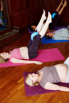 Buy stock photo Pregnant woman, prenatal and yoga class for wellness, health and maternity with stomach or legs. People, group and exercise in studio for cramps, back pain and belly with challenge, energy or balance