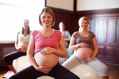 Buy stock photo A group of smiling pregnant women sitting on exercise balls at a prenatal class