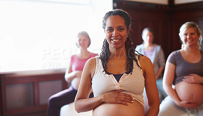 Buy stock photo A group of smiling pregnant women sitting on exercise balls at a prenatal class