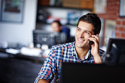 Buy stock photo A young entrepreneur looking away thoughtfully while waiting for a client to pick up his call