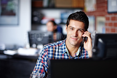 Buy stock photo Portrait of a confident young designer taking a call from a client at his desk