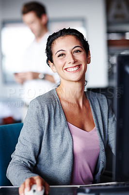 Buy stock photo A young designer smiling at you confidently while working on a computer