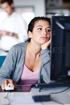 Buy stock photo A bored young businesswoman staring at her computer screen