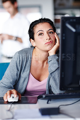 Buy stock photo A bored young businesswoman frowning with a hand on her cheek