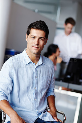 Buy stock photo A confident young businessman with his colleagues blurred in the background