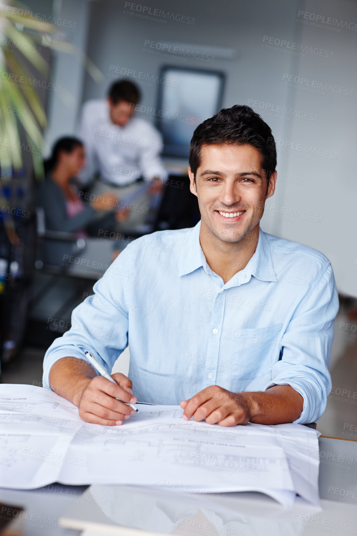 Buy stock photo Portrait of a confident young architect working on his blueprints at the office